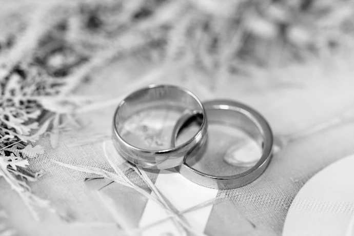 gold wedding band on white textile